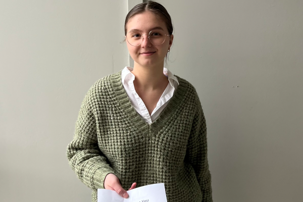 a photograph of Faith Fursman posing with their paper on rabies
