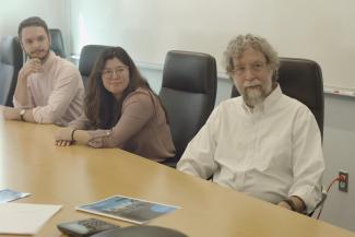 a photograph of Dr. John Lyons, Diamond Darling and Brian Turner at a conference table